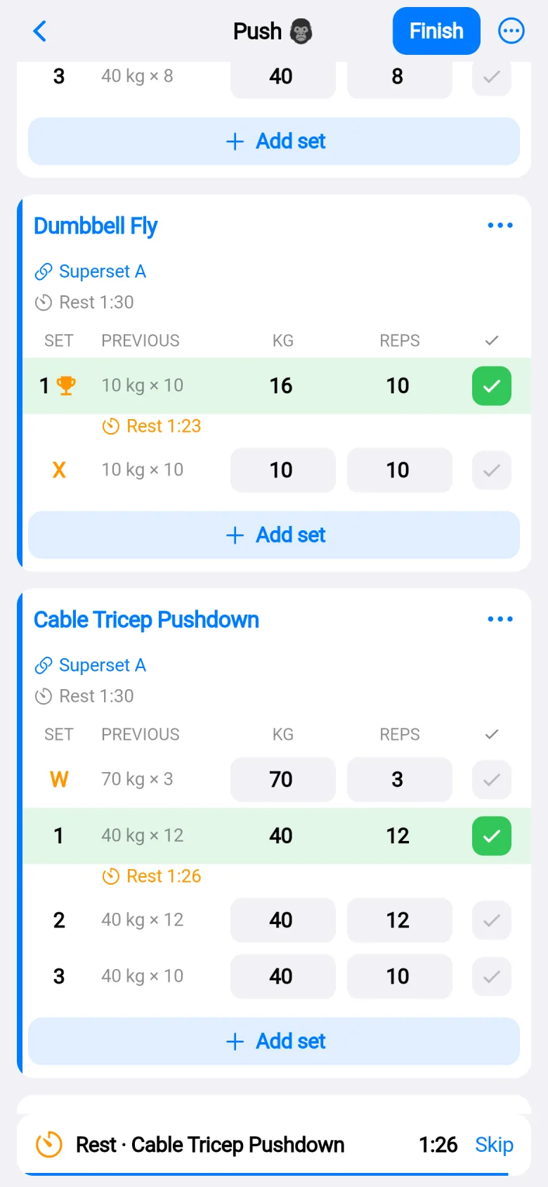 Two exercises linked as Superset A with a blue stripe, a rest timer counting down under a set, and a banner at the bottom: Rest, Cable Tricep Pushdown, 1:26, Skip.